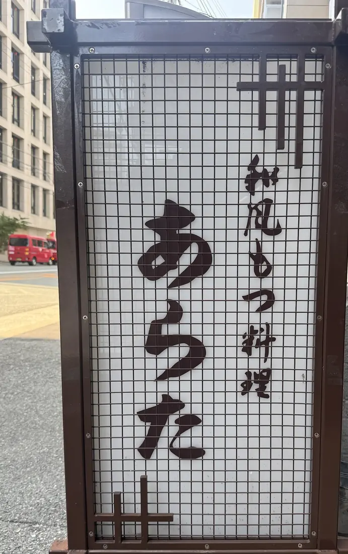 通りに立つ行灯看板「和風もつ料理 あらた」